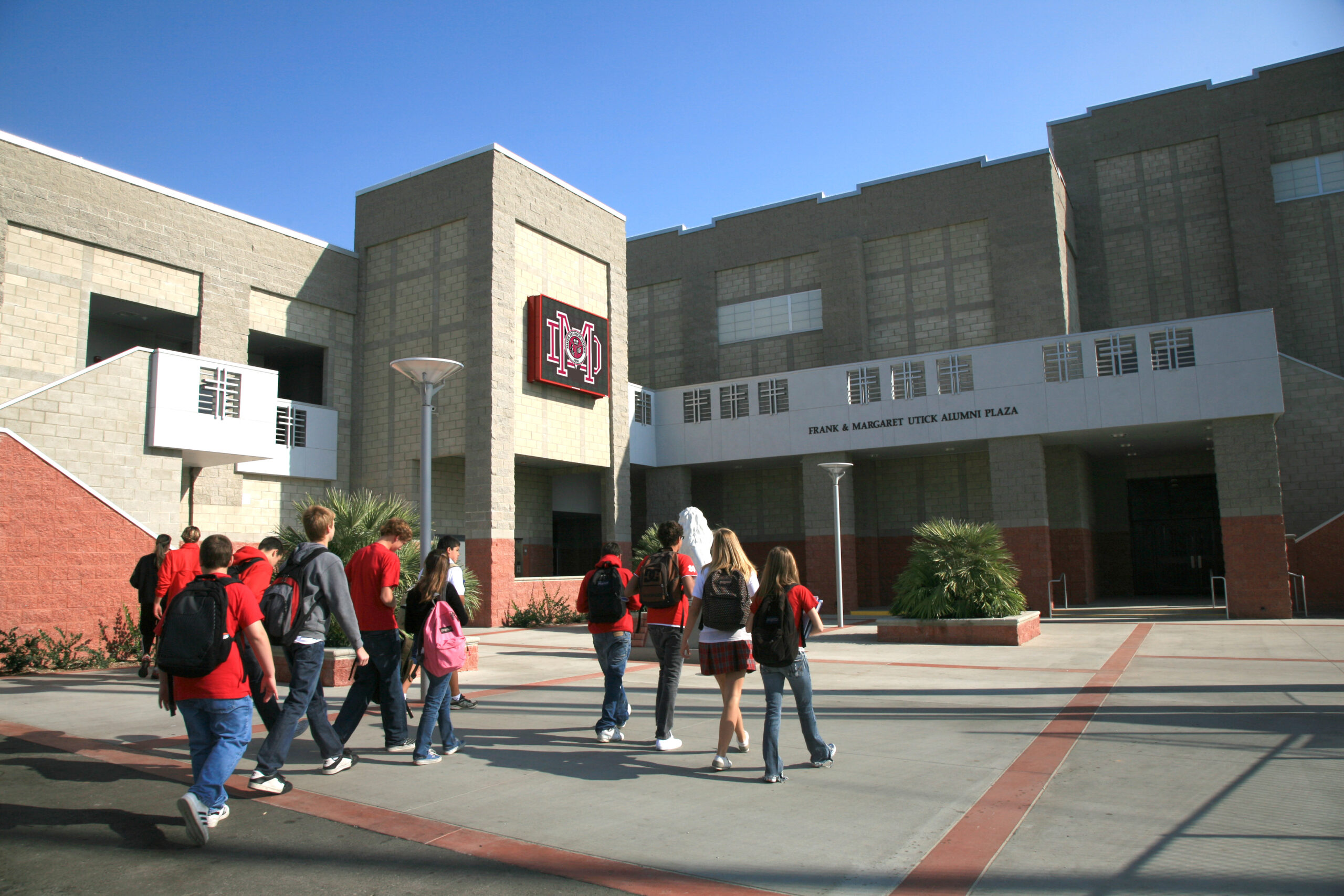 Students walking across a courtyard into school building